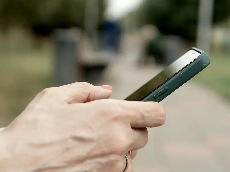 Açık havada akıllı telefon tutan bir el yakından
