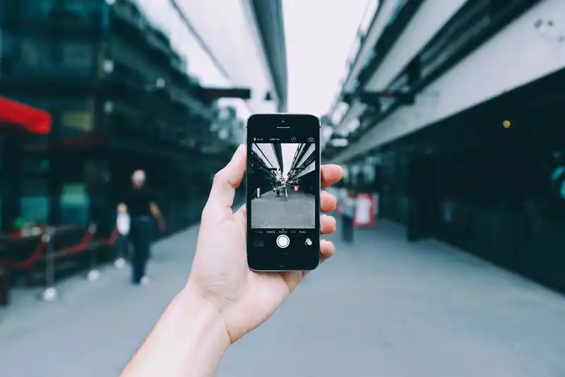 Akıllı telefonla sokakta fotoğraf çeken el yakından görünüm