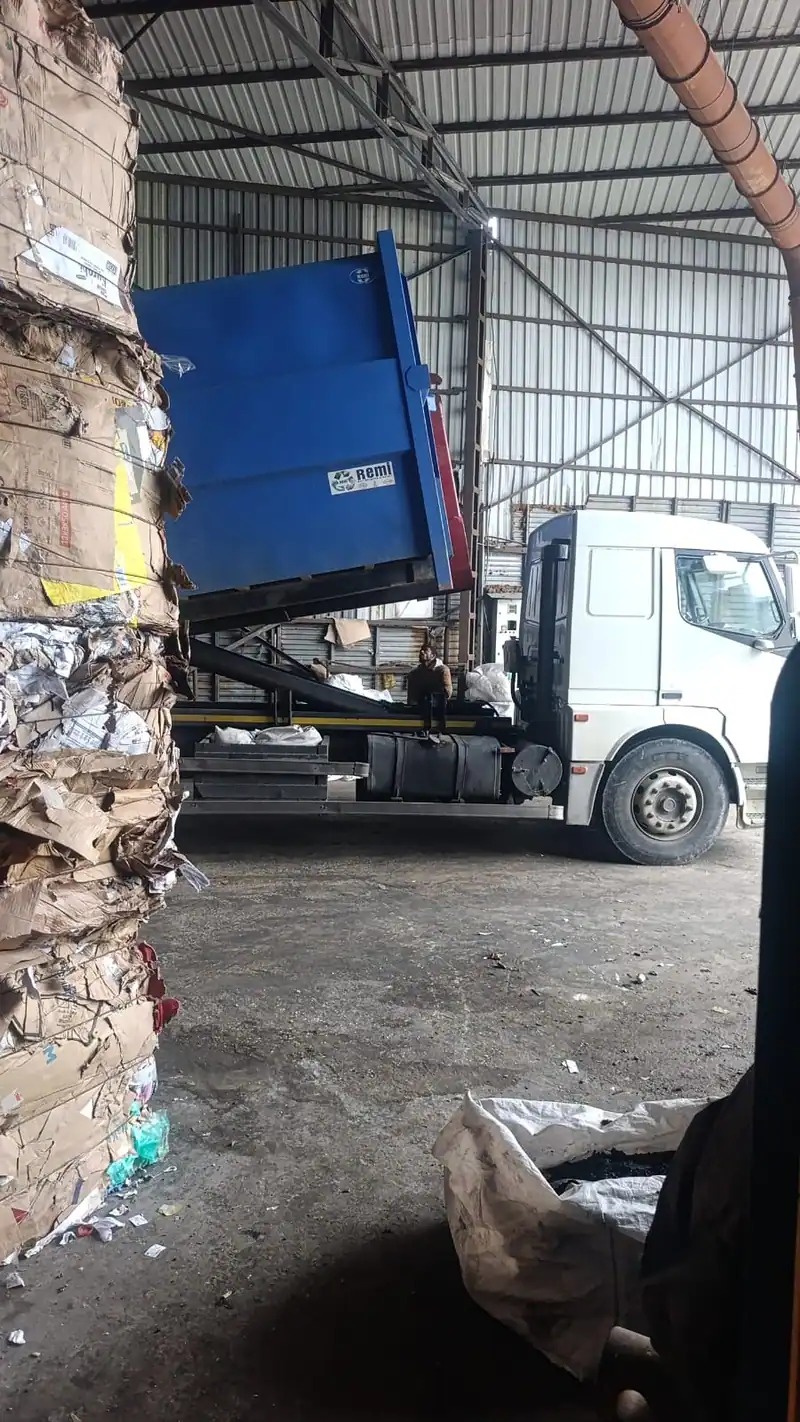 Orhunlar tesisinde konteyner indiren kamyon ve karton balyaları